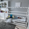 Cama montessori con casita de madera color blanco en habitación